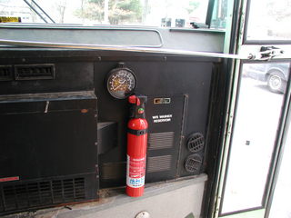 fire extinguisher mounted by front door of bus